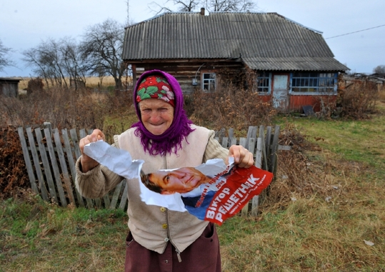 Vesničanka trhá na kusy volební plakát politika, který jí nejde pod nos.